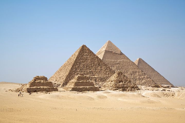 Die drei großen Pyramiden von Gizeh und kleinere Königinnenpyramiden unter blauem Himmel