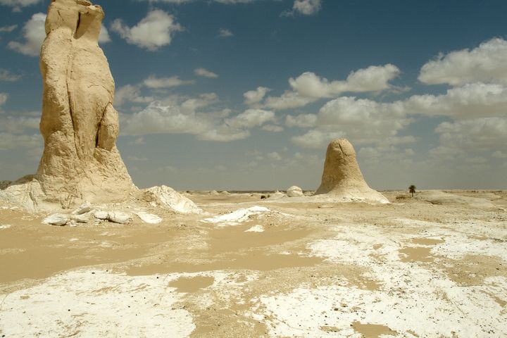 Weiße, pilzförmige Kalkfelsen unter blauem Himmel mit Wolken